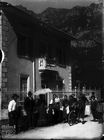 Piazza Brembana. Gruppo di persone davanti a casa Gambirasio