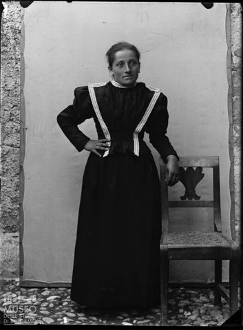 Val Brembana. Ritratto di donna appoggiata a una sedia