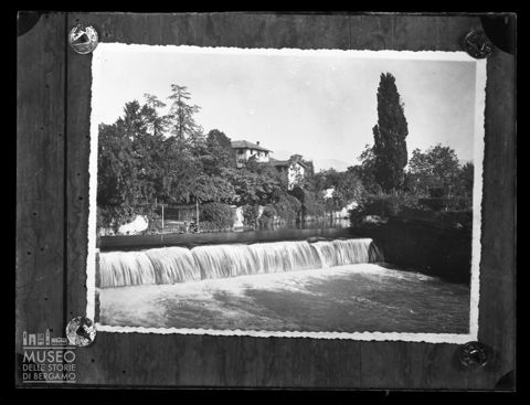 Abitazioni e donna al lavoro nei pressi di una piccola cascata