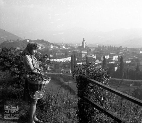 Ragazza con cesta di frutta presso un belvedere