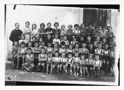 Gruppo di bambini con il prete