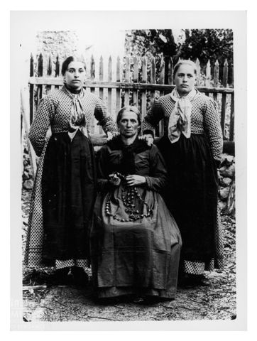 Ritratto di donna con due ragazze e la corona del rosario in mano