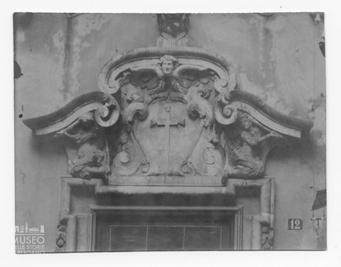 Croce entro stemma in pietra sovrastante il portale di una chiesa