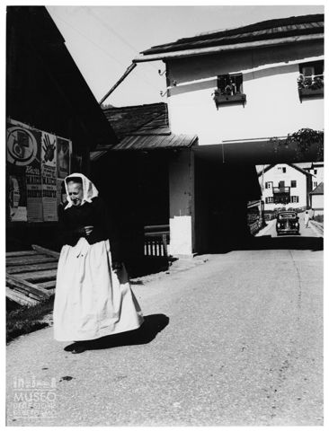 Donna anziana in costume tradizionale in un paese di montagna