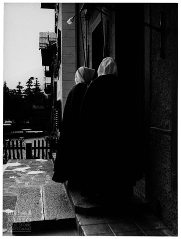 Due donne attendono alla porta di una casa