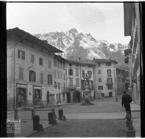 Piazza con statua e negozi