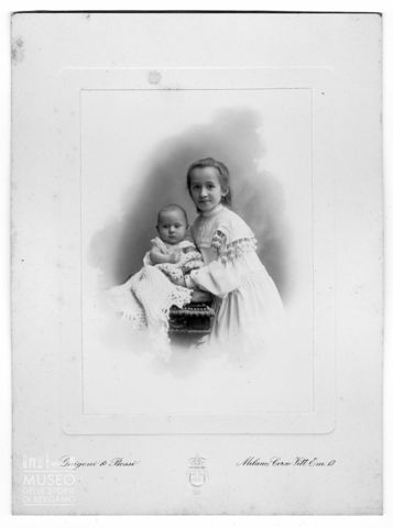Ritratto di bambina in abito bianco e infante