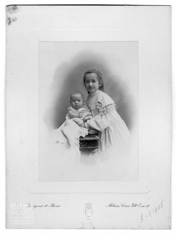 Ritratto di bambina in abito bianco e infante