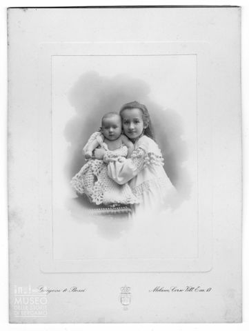 Ritratto di bambina in abito bianco e infante