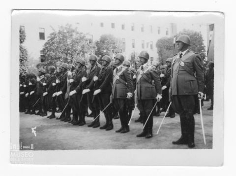 Alcuni militari schierati impugnano le armi durante una Festa di Reggimento