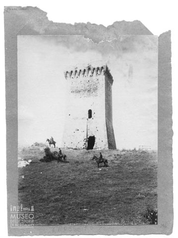 Gruppo di uomini a cavallo davanti ad una torre