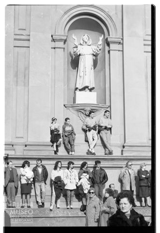 Astanti osservano la sfilata di mezza quaresima a ridosso della chiesa dei Santi Bartolomeo e Stefano a Bergamo