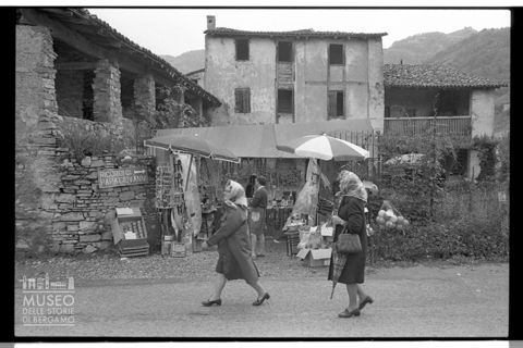 Due donne davanti a una bancarella di souvenir religiosi