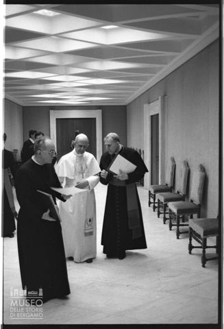 Paolo VI si consulta con un prelato e con monsignor Paquale Macchi in un corridoio dell'Aula Paolo VI