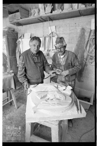 Ritratto di Floriano Bodini e Virginio Gussoni insieme a un rilievo raffigurante colombe