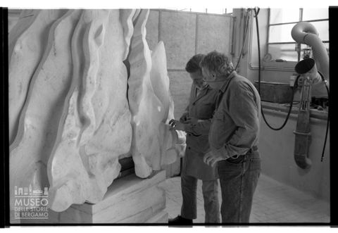 Floriano Bodini insieme a un altro uomo lavora al monumento a Paolo VI