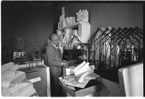 Ritratto di Sandro Angelini all'interno del suo studio con opere della serie 