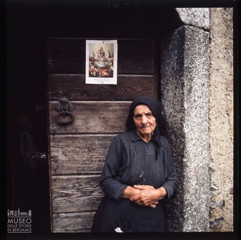 Ritratto di una donna davanti alla porta di casa a Nadro