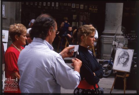 Artista esegue il ritratto di una ragazza davanti agli Uffizi a Firenze