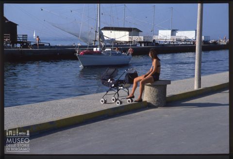 Donna con passeggino in riva al mare