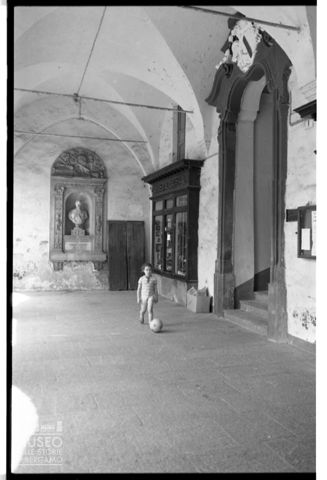 Una bambina sotto i portici di Piazza di Mondovì