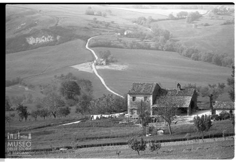 Paesaggio collinare marchigiano con edificio rurale