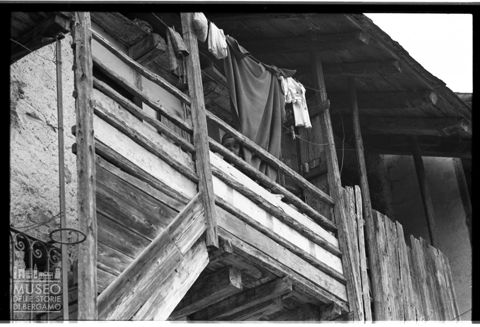 Bambino che scruta da un balcone in Val Gandino