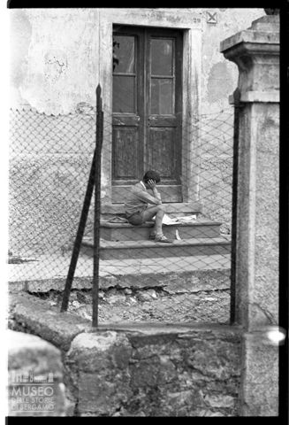 Bambino seduto che legge in Val Gandino