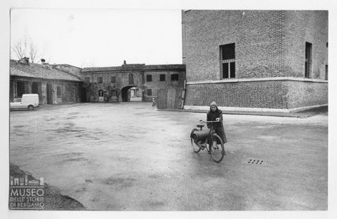 Donna con bicicletta in uno spiazzo