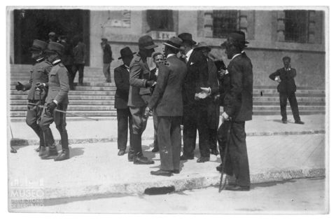 Conversazione tra militari fascisti e uomini in abiti civili in piazza Dante a Bergamo