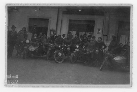 Ritratto di gruppo di motociclisti con altre persone