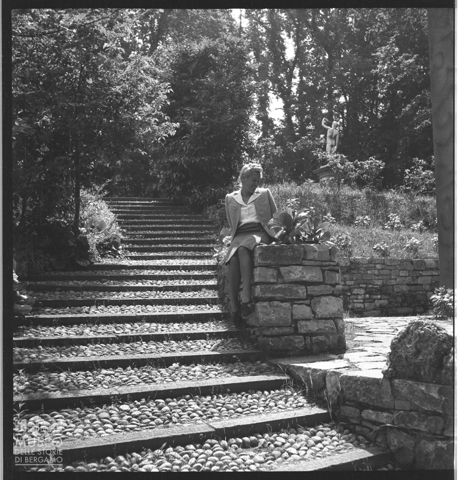 Giovane donna nel giardino di una villa