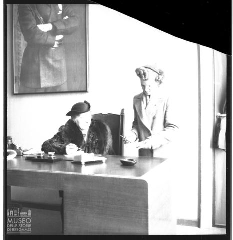 Due signore in abiti eleganti alle prese con documenti