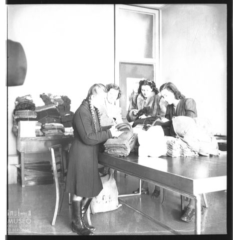 Donne al lavoro per gli indumenti dei combattenti