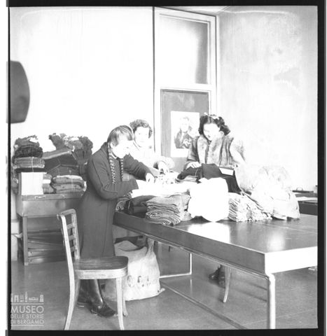 Donne al lavoro per gli indumenti dei combattenti