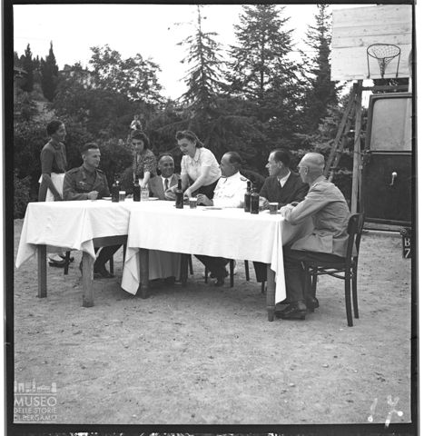 Donne servono il pranzo a ufficiali nazisti e persone in abiti civili