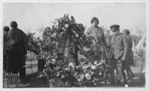Ritratto di una donna e un ragazzo dietro ad una lapide dedicata a Cristoforo Pentagna morto durante la Prima guerra mondiale