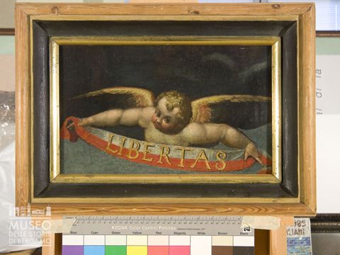 Angelo con nastro bianco e rosso con scritta 