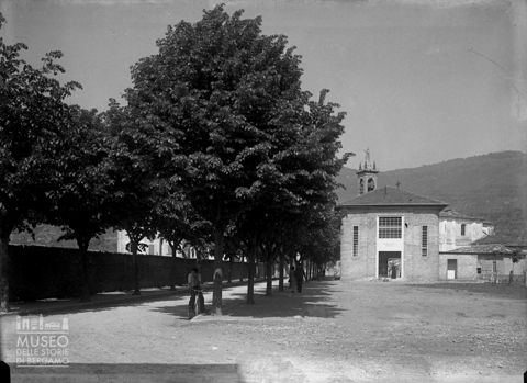 Via alberata con cinema e oratorio