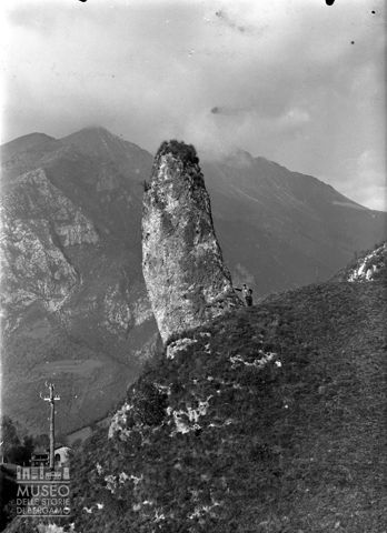 Uomo accanto a un masso