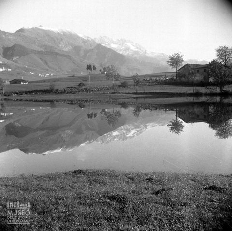 Laghetto con alberi e monti
