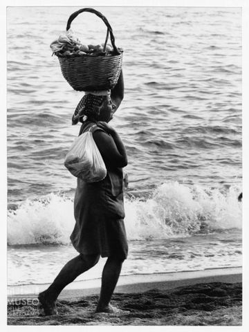 Donna al mare con cesto di frutta