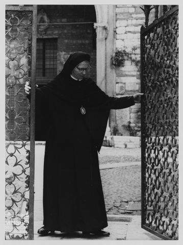 Suora che apre un cancello
