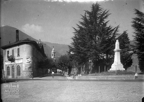 Via Marconi con attività commerciale e monumento ai caduti