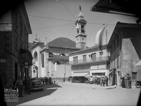 Gazzaniga, chiesa parrocchiale e scorcio di una via