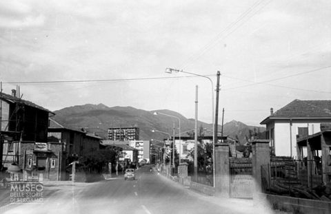 Gazzaniga, strada con abitazioni e automobile