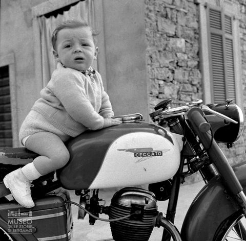 Bimbo a cavalcioni su motocicletta