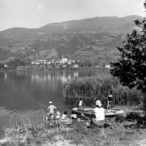 Pescatori e barche presso un canneto