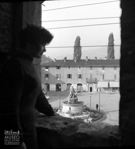 Donna affacciata su piazza Cavour